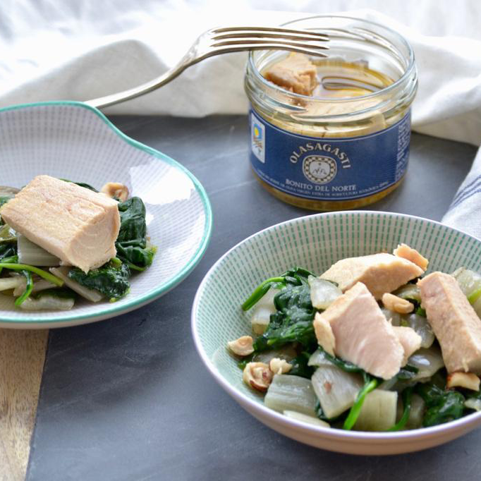 Two bowls of warm Bonito del Norte salad - Fillets in Olive Oil with sautéed vegetables. Bonito del Norte glass packaging - Fillets in Olive Oil, by Olasagasti.