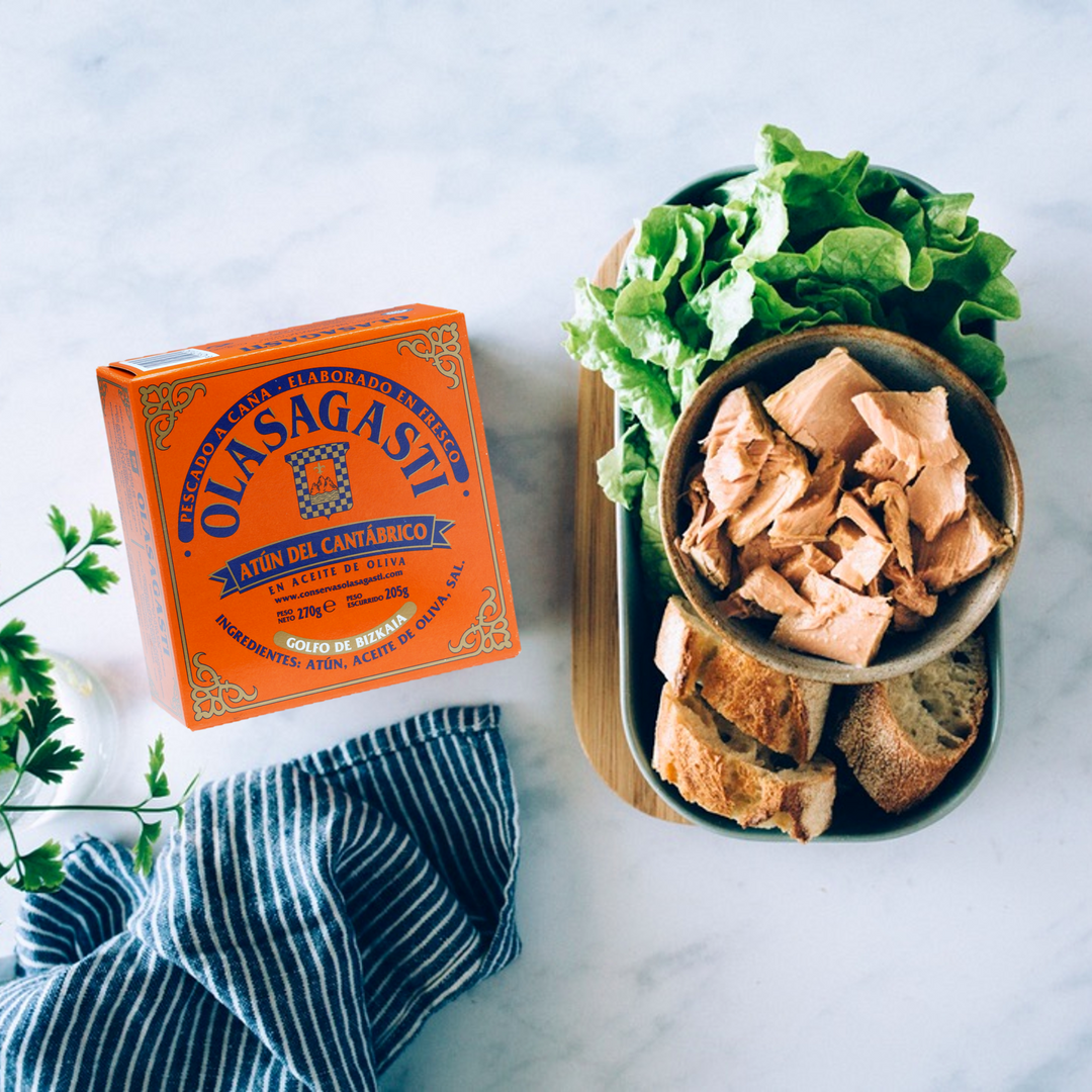 Can of Cantabrian tuna from the Olasagasti brand, accompanied by a can with pieces of bread, tuna and lettuce.