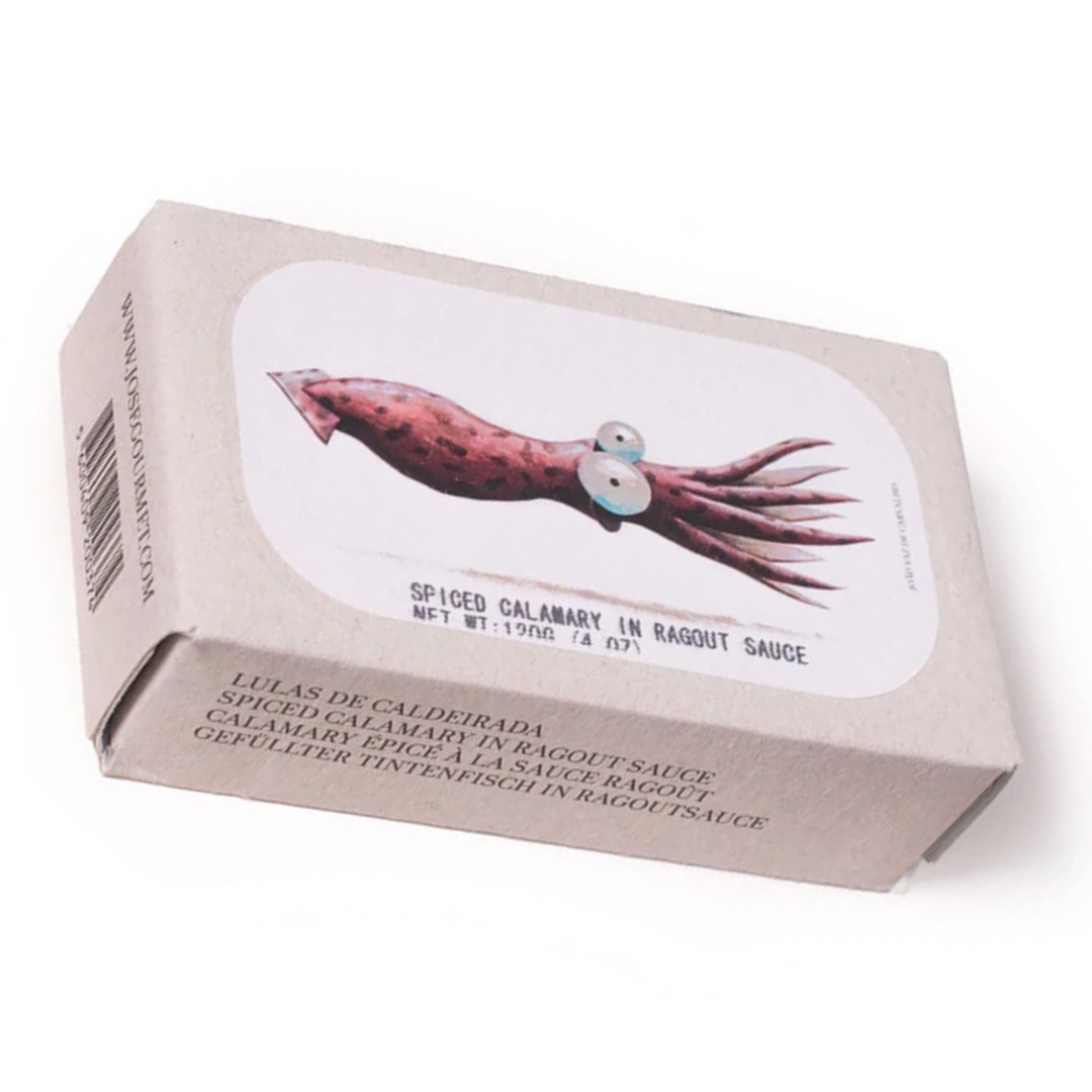 José Gourmet Spiced Calamari in Ragout Sauce (Lulas de Caldeirada). The artistic packaging features a whimsical illustration of a squid by artist João Vaz de Carvalho on a minimalist grey cardboard box. Premium Portuguese canned seafood combining traditional spiced recipes with modern graphic art.